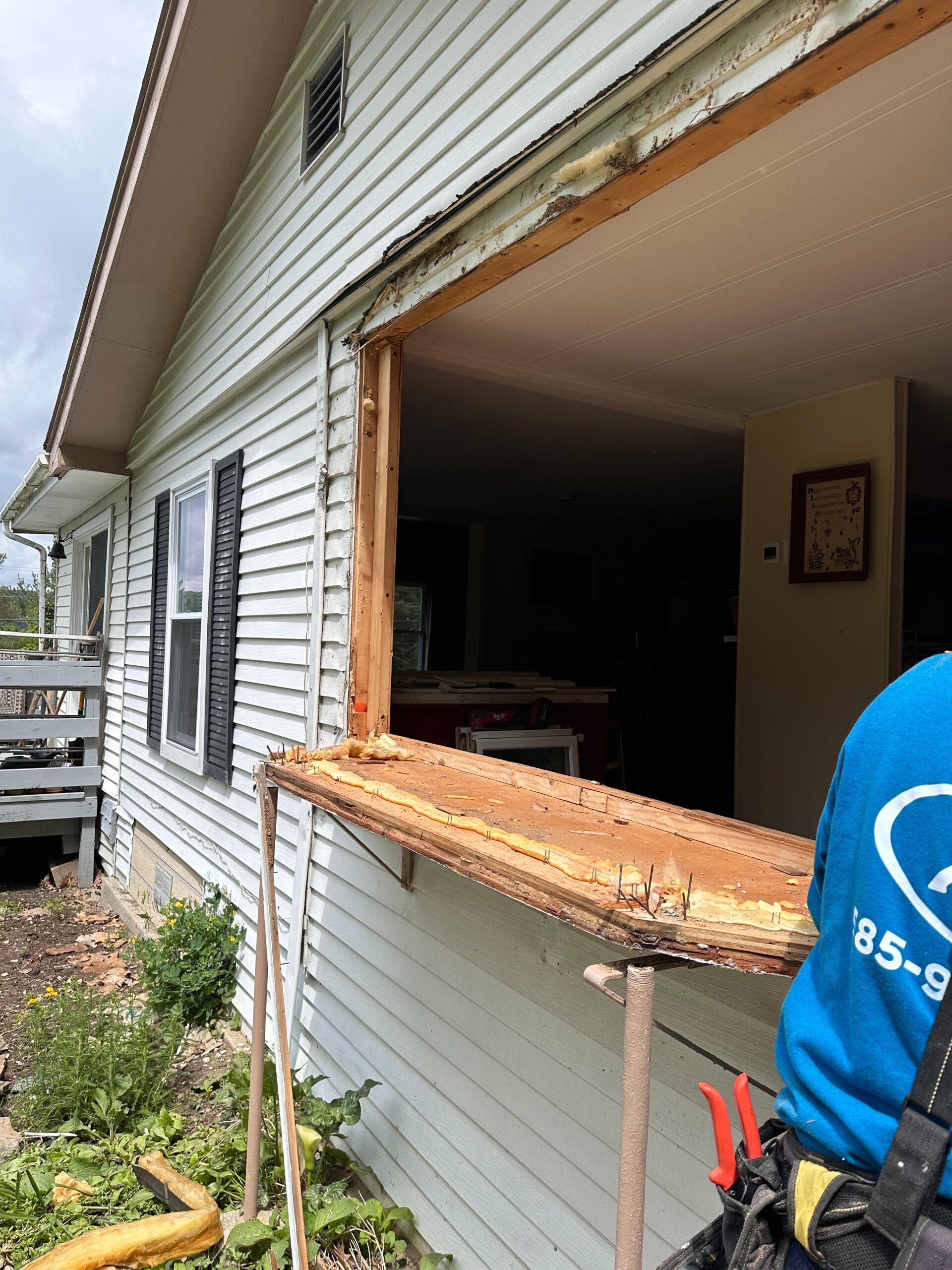 Before photo of an outdated home exterior with drafty, inefficient windows prior to a new vinyl replacement window installation in Cayuga County, NY