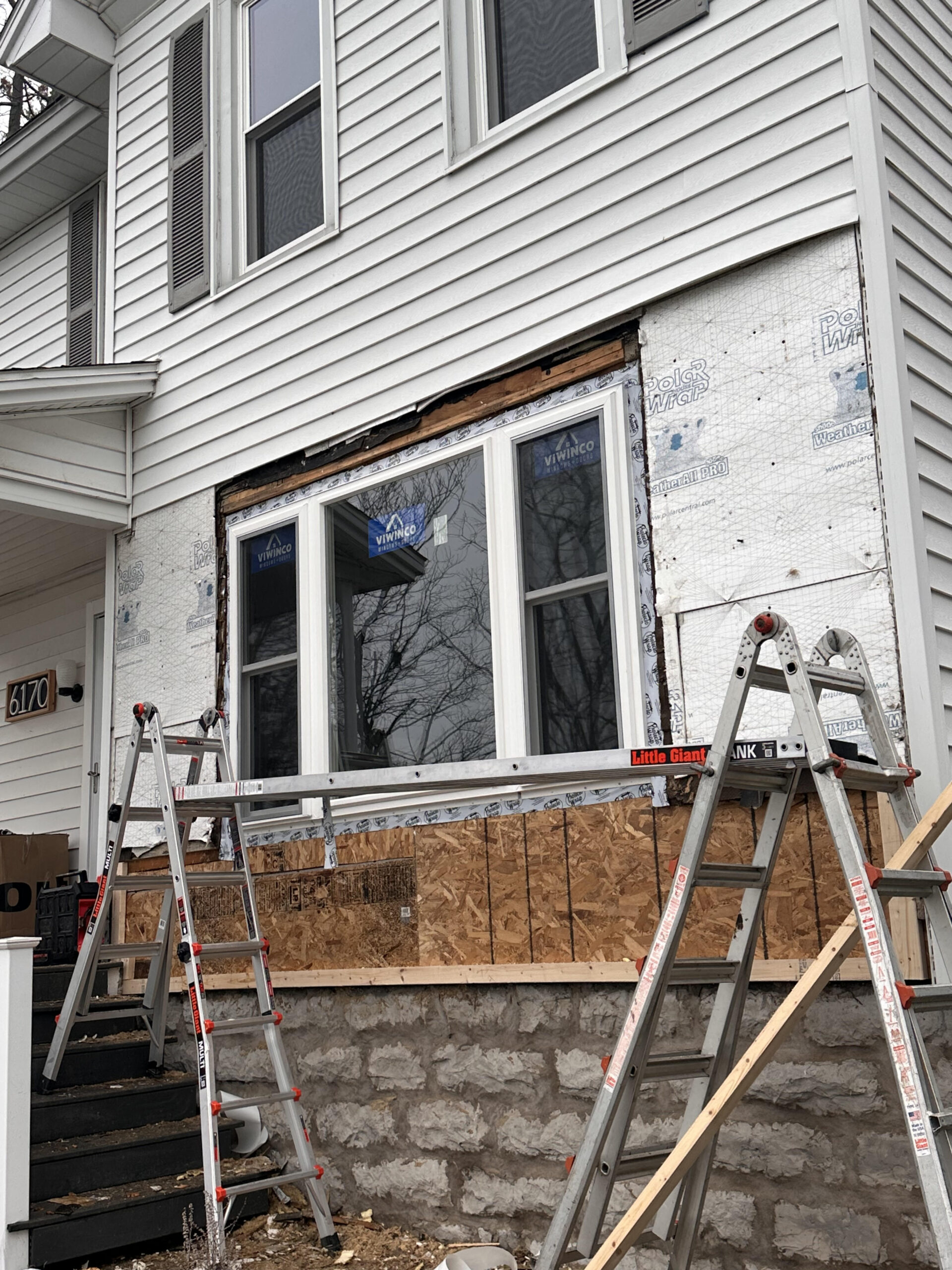 Exterior renovation of a Cayuga Lake vacation rental featuring a custom deck, new vinyl siding, and updated windows