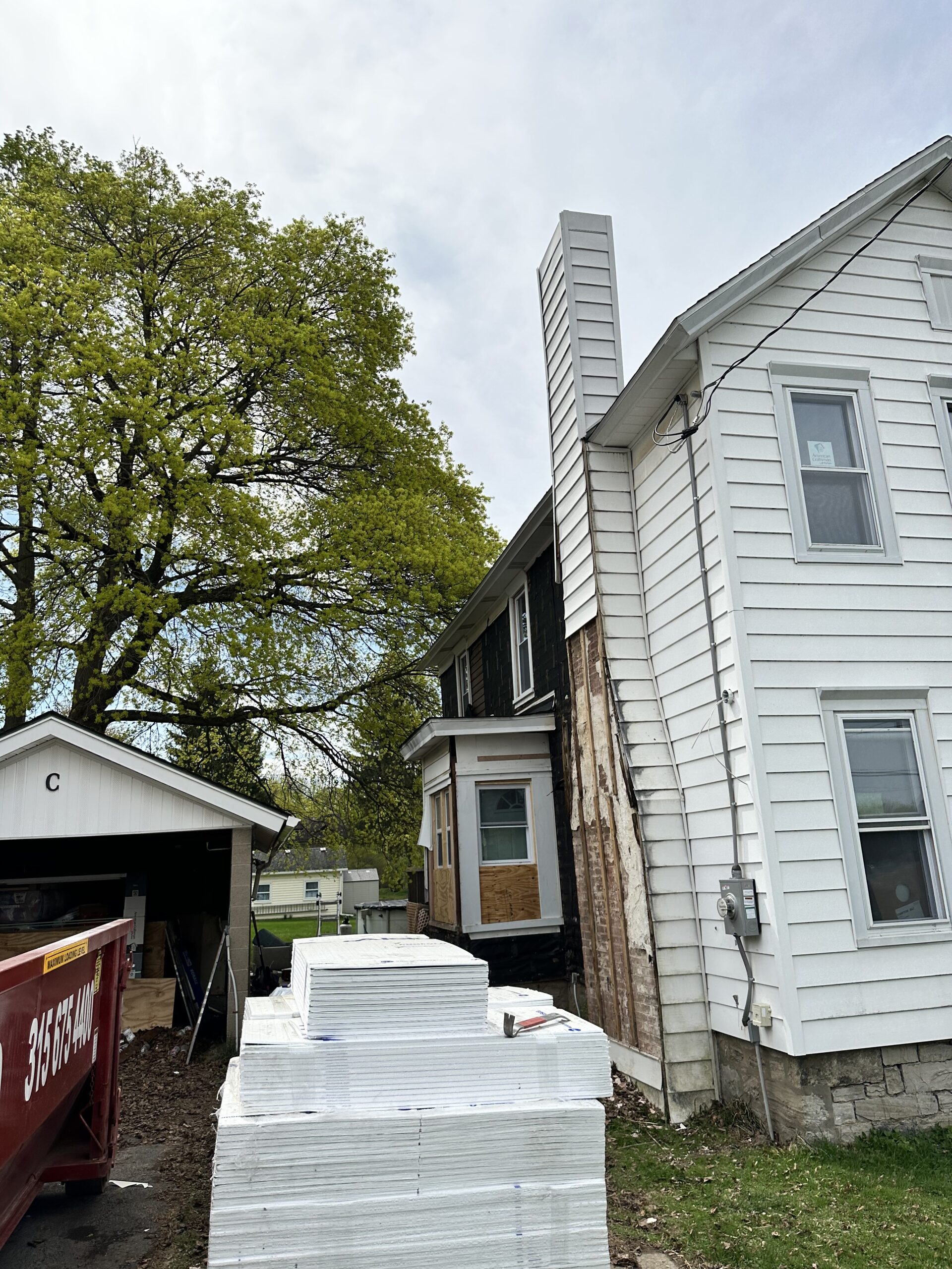 Before photo of an aging two-story home exterior requiring new vinyl siding in Cayuga County