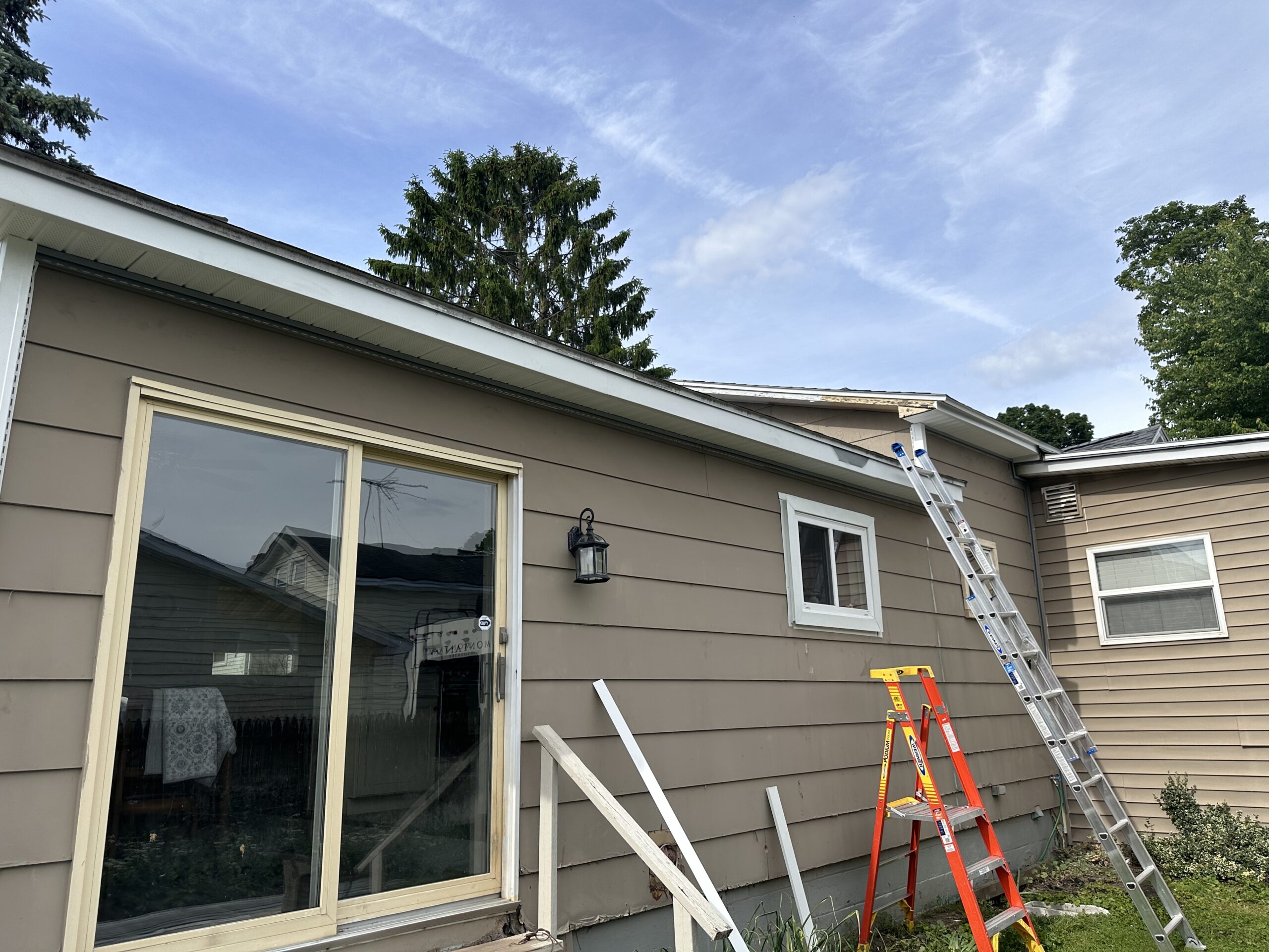Before photo showing old, weathered exterior before new vinyl siding installation