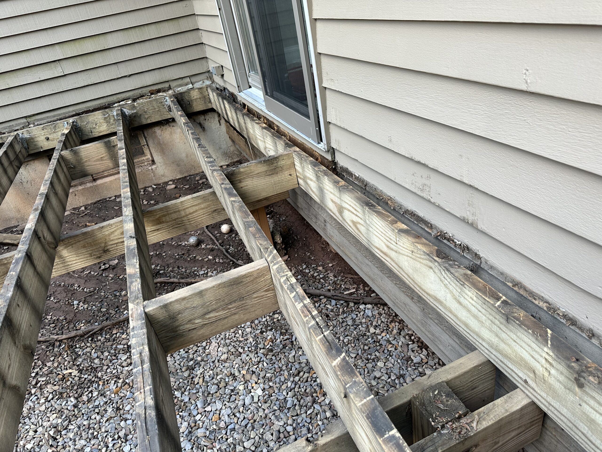 Close-up of rotting deck boards targeted for a full TimberTech deck replacement