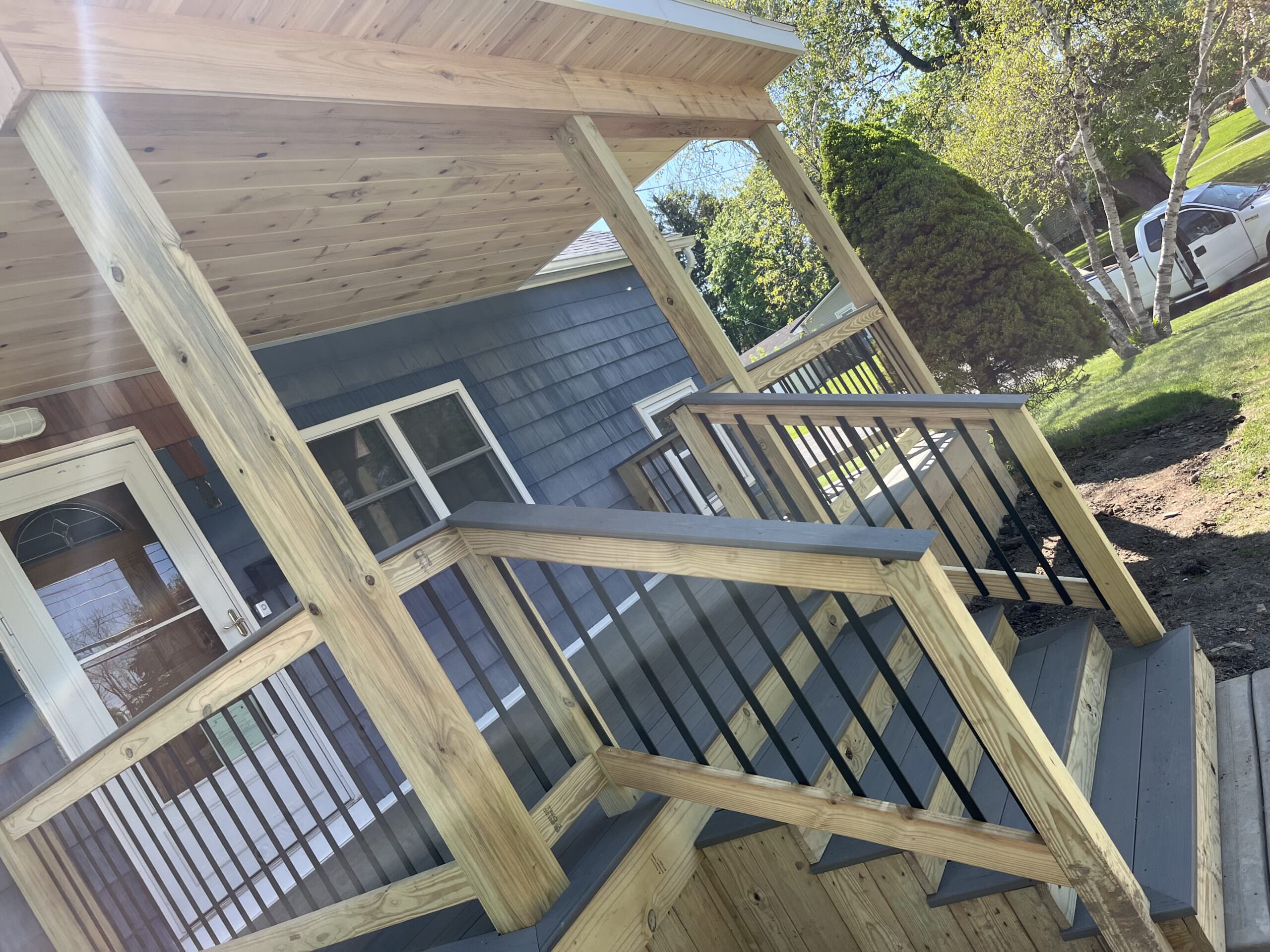 Custom cedar soffit and poly wood ceiling on a new residential covered porch in Cayuga County