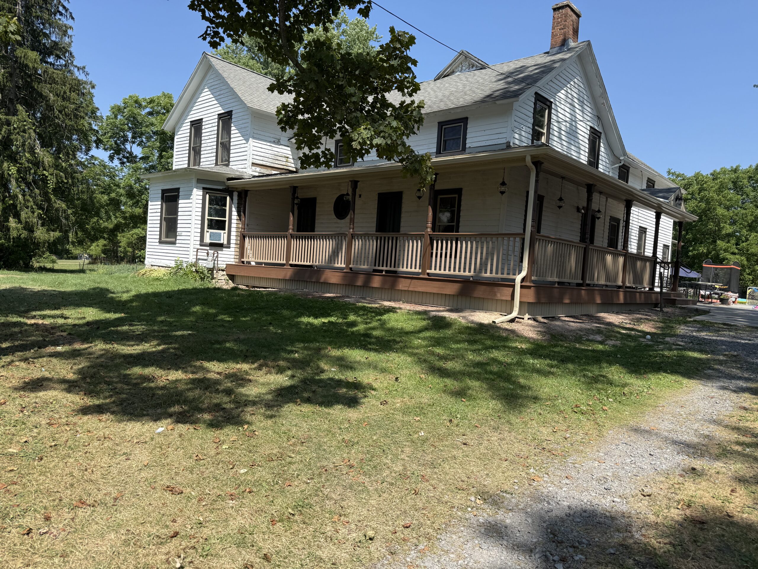 Beautifully restored 100-year-old farmhouse wrap-around porch featuring TimberTech decking in Fleming NY