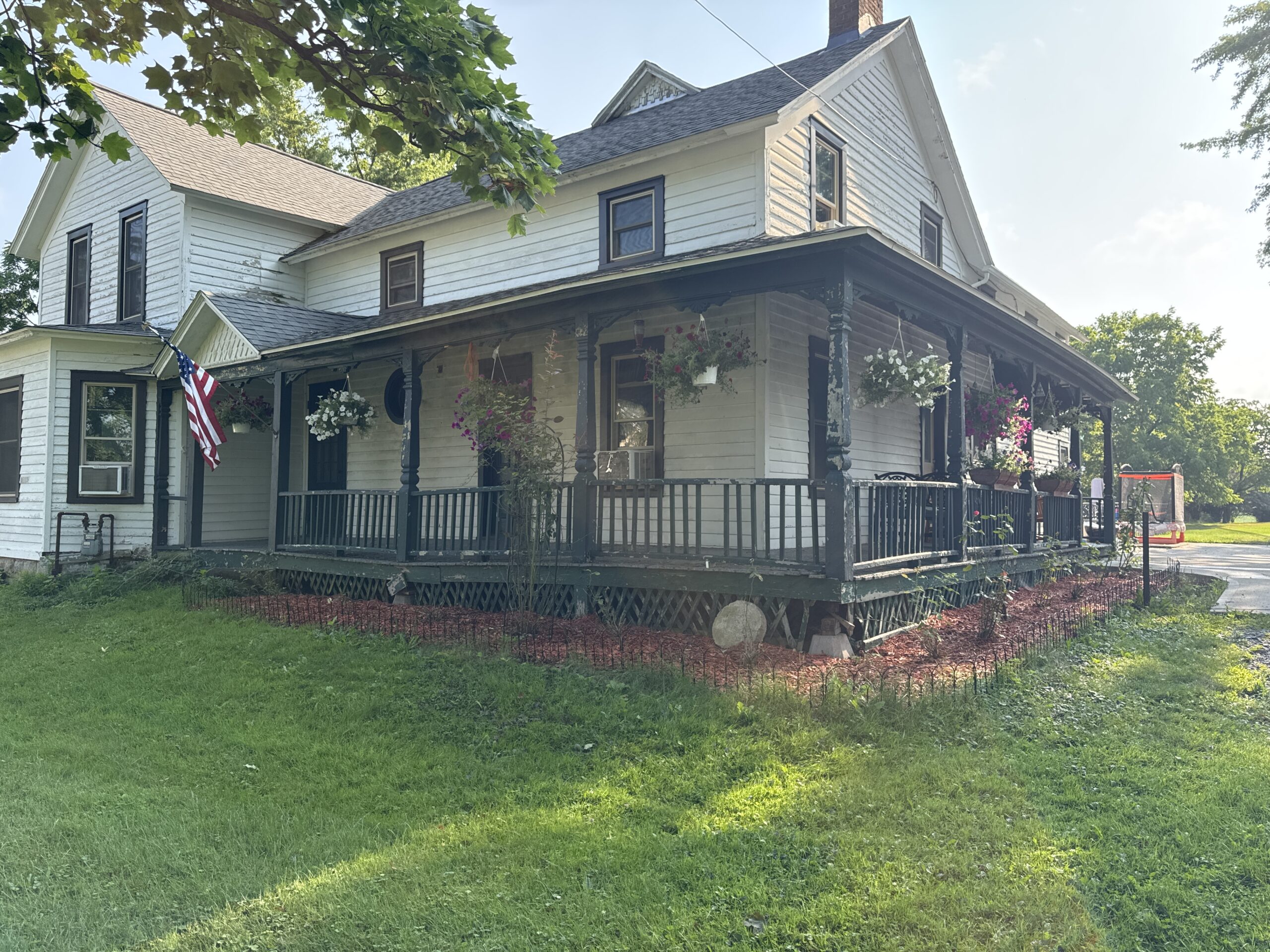 Before photo showing rotting wood and structural damage on an original 100-year-old farmhouse porch