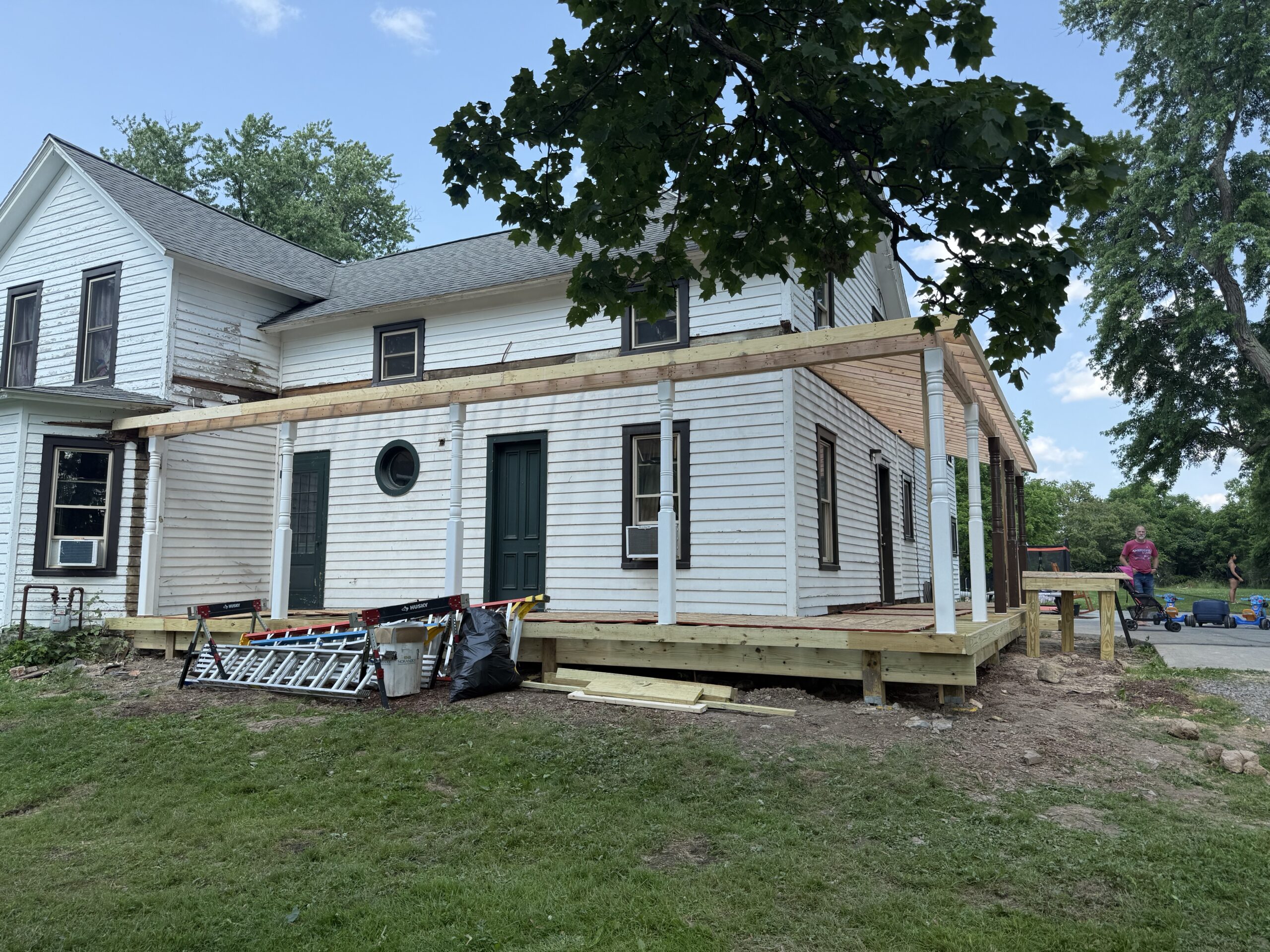 WeBuild CNY contractors installing premium TimberTech PVC decking on a wrap-around porch