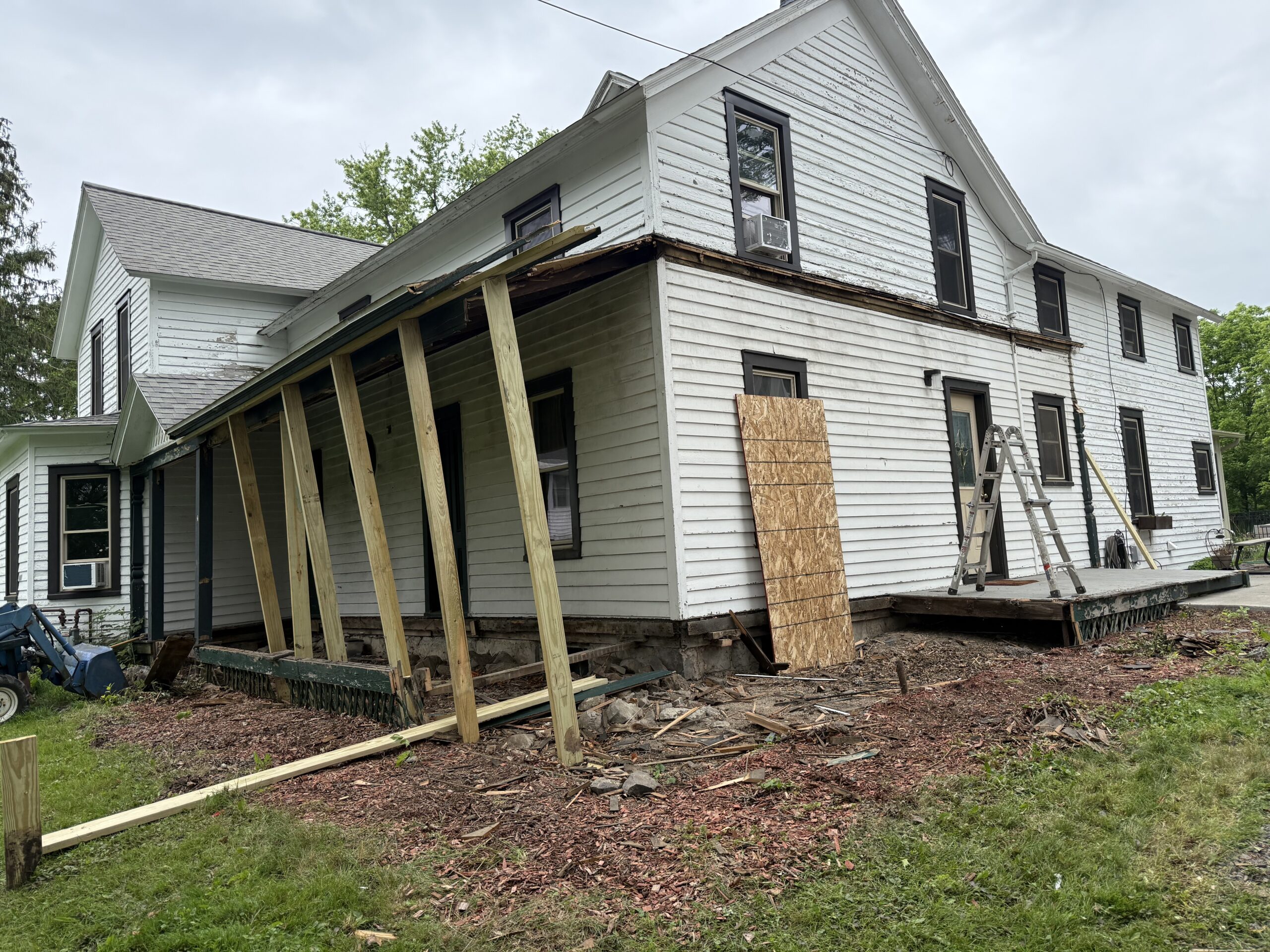 Seamless gutter installation and final construction phases of a farmhouse wrap-around porch rebuild